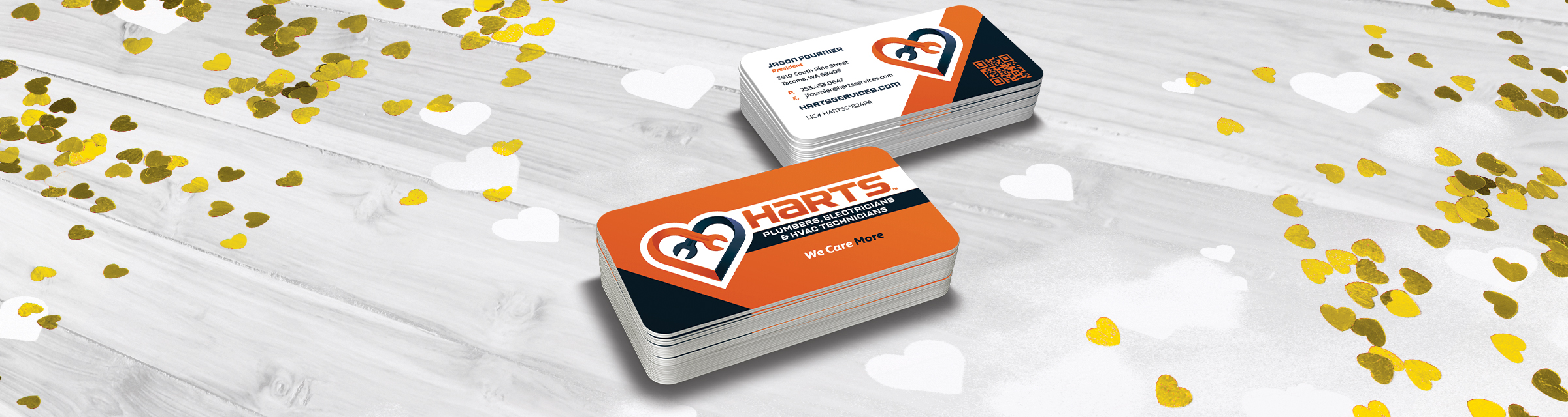 harts business cards on top of white and gold heart shaped confetti